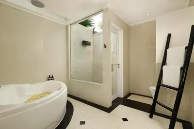 a bathroom with a toilet and a sink and a shower at Shanti Estate Seminyak by Nakula in Seminyak