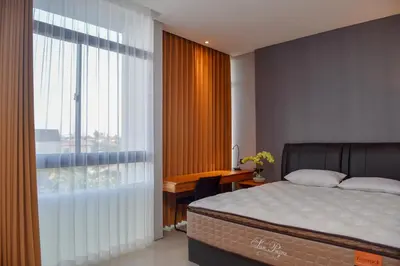 a bedroom with a bed and a desk and a window at MINI Coliving Apartment in Seminyak