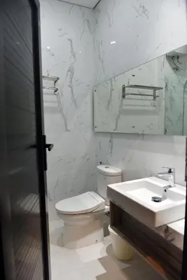 a white bathroom with a toilet and a sink at MINI Coliving Apartment in Seminyak
