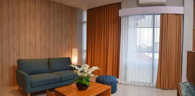 a living room with a couch and a table and a window at MINI Coliving Apartment in Seminyak