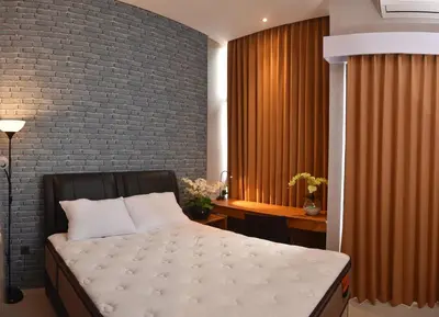 a bedroom with a bed and a brick wall at MINI Coliving Apartment in Seminyak