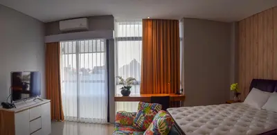 a bedroom with a bed and a tv and a window at MINI Coliving Apartment in Seminyak