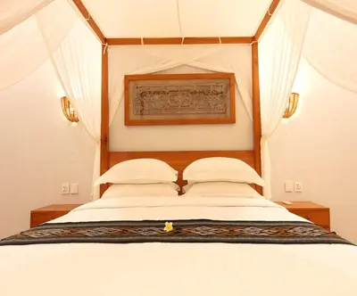 a bedroom with a bed with a wooden head board at Sarayu Villa 2 - Serene and peaceful 2BR private Villa in Seminyak
