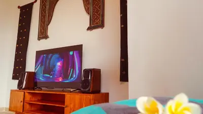 a tv sitting on a wooden stand with a speaker at Sarayu Villa 2 - Serene and peaceful 2BR private Villa in Seminyak