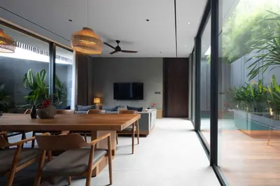 a dining room with a table and a couch at ALENY Vila by VoLa in Seminyak