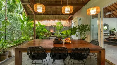 a dining room with a wooden table and chairs at Villa Celeste by Villa Finder in Seminyak