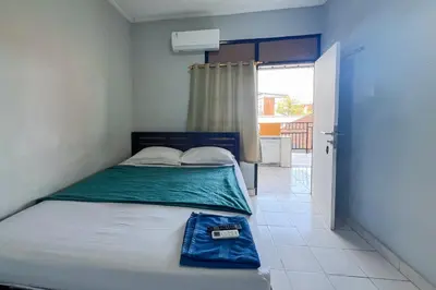 a small bedroom with a bed with a sign on it at SN Guest House Near Trans Studio Mall in Legian