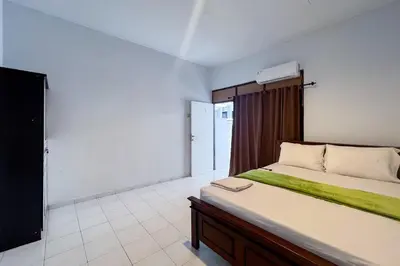 a bedroom with a large bed and a television at SN Guest House Near Trans Studio Mall in Legian
