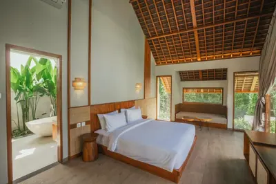 a bedroom with a bed and a bathroom with a tub at Arpana Luxury Private Pool Villas in Jimbaran