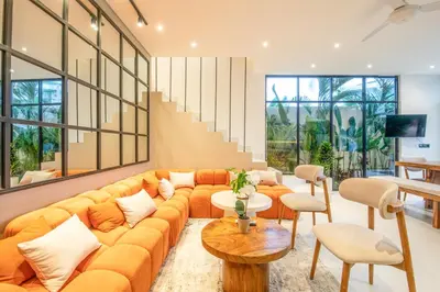 a living room with an orange couch and chairs at Marvelous 6BR 2 mins to Beach in Canggu