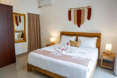 a bedroom with a large white bed with two lamps at Villa Majegau 4 Seminyak in Seminyak
