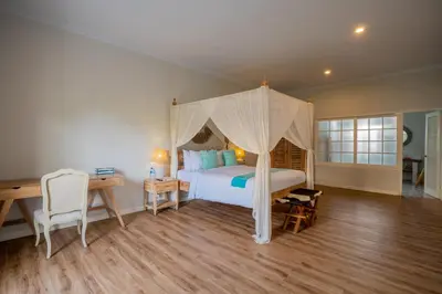 a bedroom with a bed and a desk and a bed sidx sidx sidx at Deja Blu Villa in Seminyak