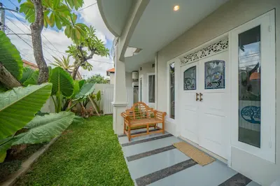 a porch of a home with a wooden bench at Deja Blu Villa in Seminyak