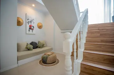 a white staircase with a bench in a house at Deja Blu Villa in Seminyak