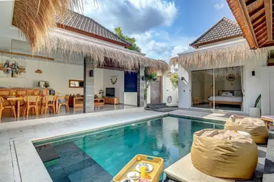 a villa with a swimming pool and a bedroom at Villa Esha II in Seminyak