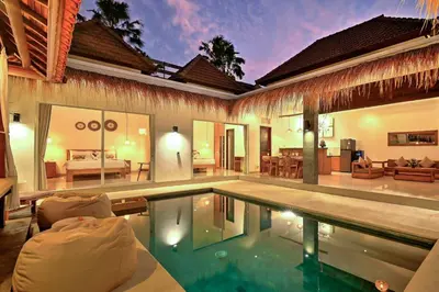 a villa with a swimming pool and a bedroom at Villa Esha II in Seminyak