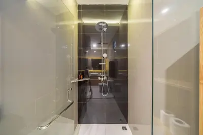 a shower with a glass door in a bathroom at Sundaze 3 - Villa with Huge Pool and Kitchen in Canggu