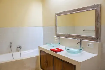 a bathroom with two sinks and a mirror and a tub at Dana Villa Bali in Seminyak