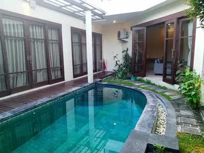 a swimming pool in front of a house at Dana Villa Bali in Seminyak