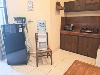 a kitchen with a refrigerator and a table in a room at Dana Villa Bali in Seminyak