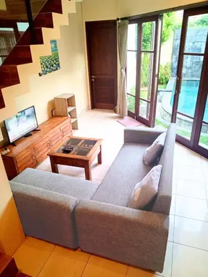 a living room with a couch and a table at Dana Villa Bali in Seminyak