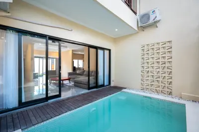 a swimming pool in a house with a living room at Villa Uma Sari in Kerobokan