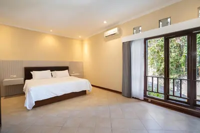 a bedroom with a bed and a large window at Villa Uma Sari in Kerobokan