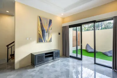 a living room with a tv and a window at Villa Uma Sari in Kerobokan
