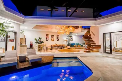 a living room with a swimming pool in a house at Boho-chic Canggu Villa near Cafè Del Mar, 5-minute walk to beach in Canggu
