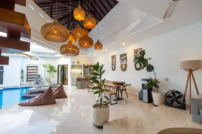 a living room with potted plants and a pool at Boho-chic Canggu Villa near Cafè Del Mar, 5-minute walk to beach in Canggu