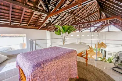 a bedroom with a bed and a table in a room at Boho-chic Canggu Villa near Cafè Del Mar, 5-minute walk to beach in Canggu