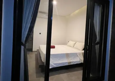 a small bedroom with a bed and a mirror at Uger House Seminyak in Seminyak