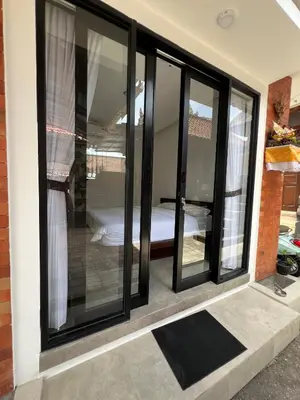 a room with black windows and a bed in it at Uger House Seminyak in Seminyak