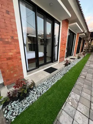 a house with a dog laying on the grass at Uger House Seminyak in Seminyak