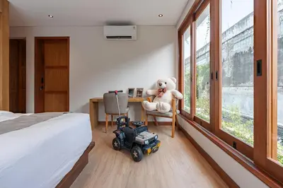 a teddy bear sitting in a chair in a bedroom at The Urban Retreat Seminyak Private Pool Villas with Butler for Families & Groups in Seminyak