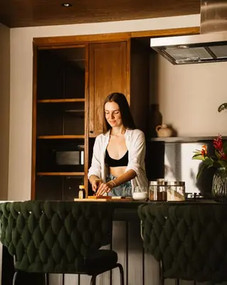 a woman standing in a kitchen preparing food at The Urban Retreat Seminyak Private Pool Villas with Butler for Families & Groups in Seminyak