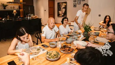 a group of people sitting around a table eating food at The Urban Retreat Seminyak Private Pool Villas with Butler for Families & Groups in Seminyak