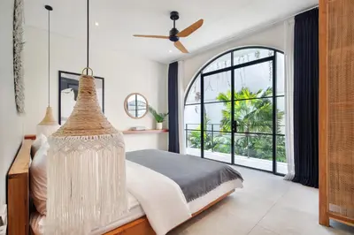 a bedroom with a bed and a large window at Villa Sugi Umalas in Canggu