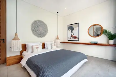 a bedroom with a large bed and a mirror at Villa Sugi Umalas in Canggu