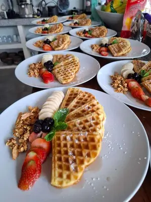 a bunch of waffles and fruit on plates on a table at Villa Sugi Umalas in Canggu