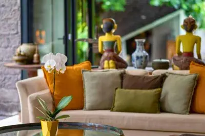 a living room with a couch with pillows and a table at Janardana 4 BR Private Pool Villa ZN157 in Canggu