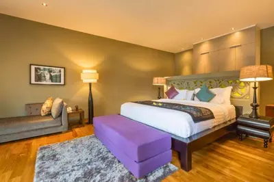 a bedroom with a king sized bed and a couch at Janardana 4 BR Private Pool Villa ZN157 in Canggu