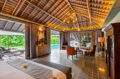 a bedroom with a bed and a living room at Janardana 4 BR Private Pool Villa ZN157 in Canggu