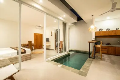 a room with a swimming pool and a bedroom at Minimalist Villa with Pool #Jade3 in Canggu