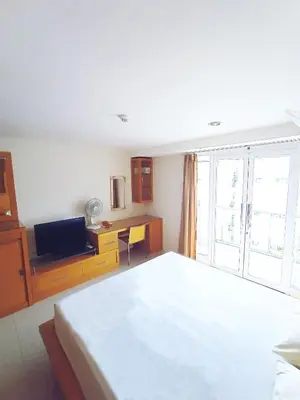 a bedroom with a bed and a desk and a television at Harris Hotel & Residences Kuta in Kuta
