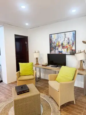 a living room with two chairs and a flat screen tv at 3 Bedroom Calla Villa in Nusa Dua