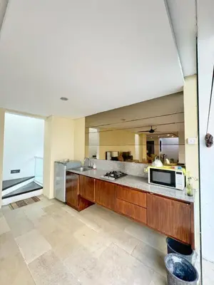 a large kitchen with a counter and a microwave at 3 Bedroom Calla Villa in Nusa Dua