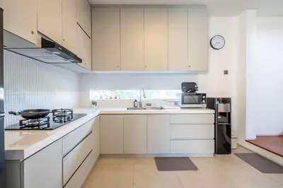 a kitchen with white cabinets and a counter top at Vinca Villa Bali in Kerobokan