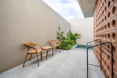 two chairs and a table on the balcony of a house at Vinca Villa Bali in Kerobokan