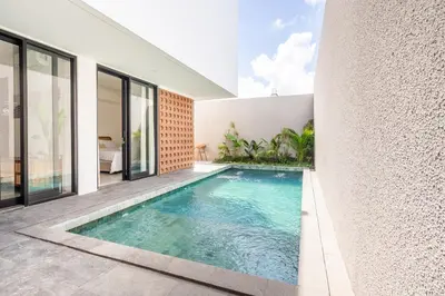 an infinity pool in the backyard of a house at Vinca Villa Bali in Kerobokan